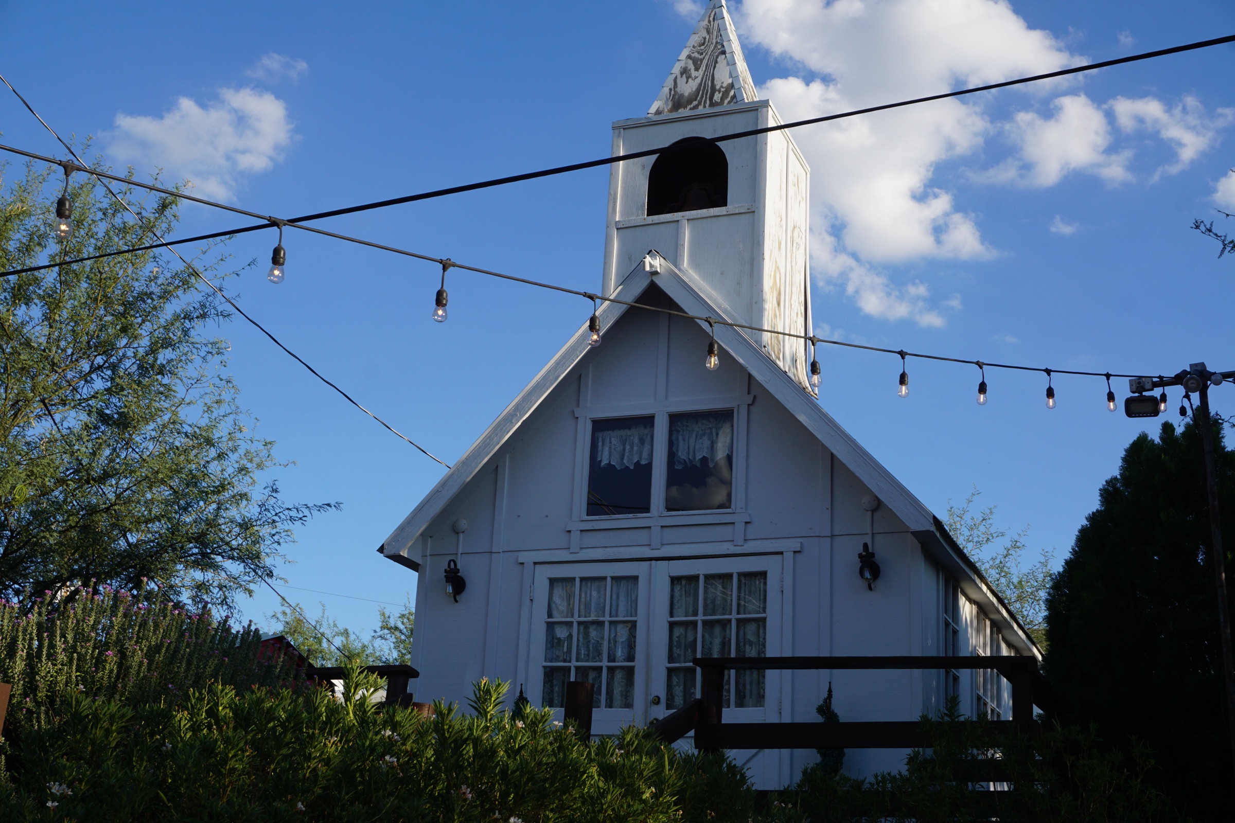 White wedding chapel with a steeple under a blue Arizona sky